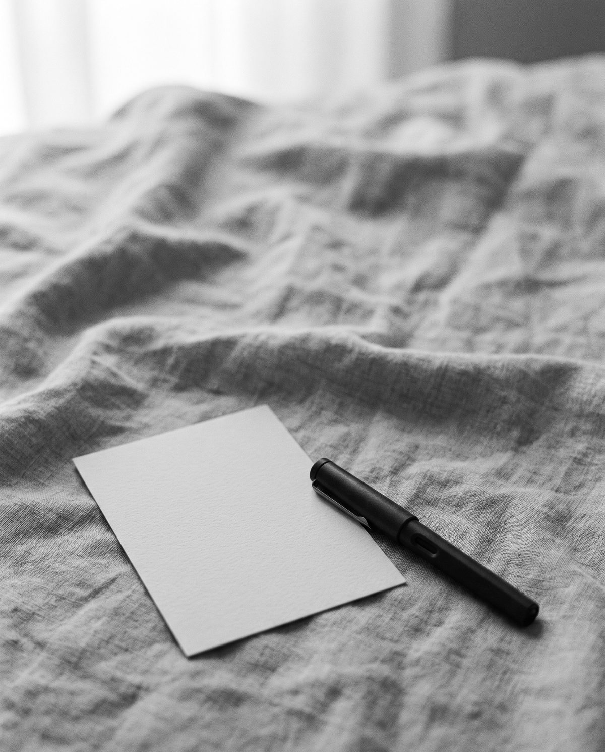 A blank card and a fountain pen on folded linen.
