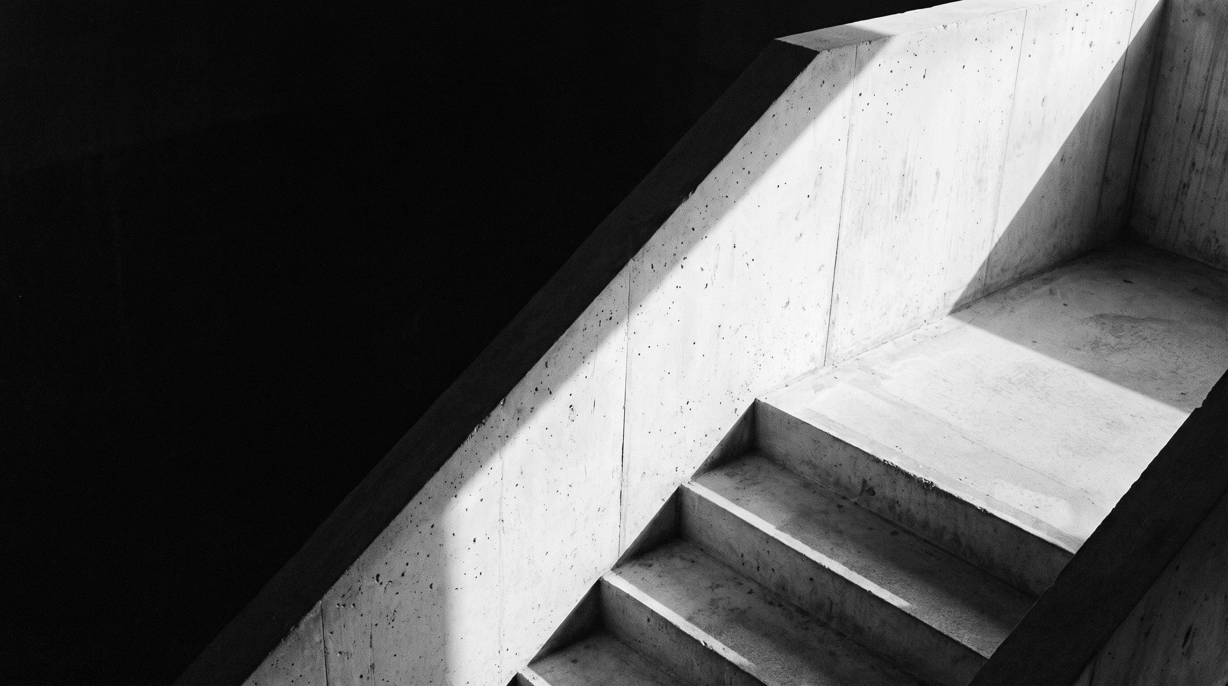 Light falling across a raw concrete staircase.